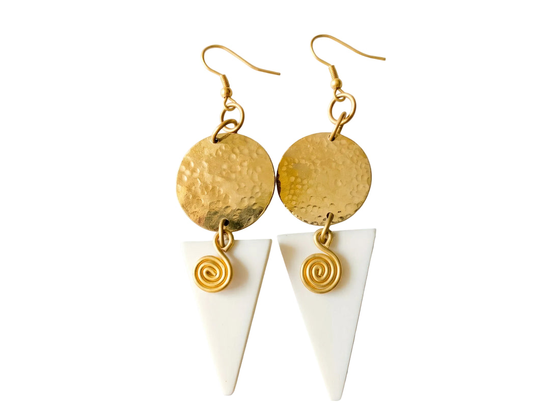 A pair of bohemian-style dangle earrings featuring hammered gold-tone circular discs, white triangular drop charms, and small gold spiral accents, displayed on a clean white background.